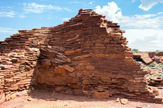 Who built this wall at Wupatki Pueblo?