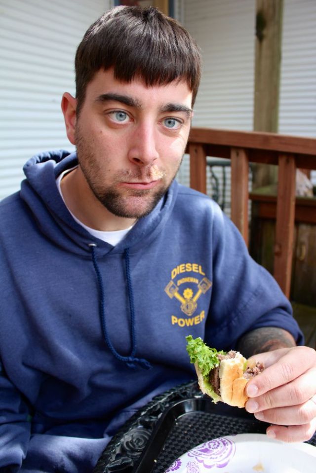 Caleb eating the caribou burger from the BBQ Shack