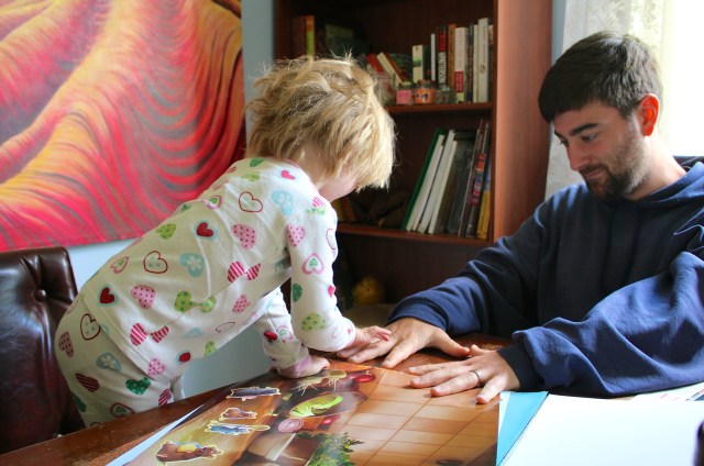 Lyra looking at Caleb's tattoo