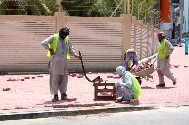 masons re-bricking the sidewalk