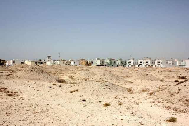 ancient burial mounds in front of modern houses